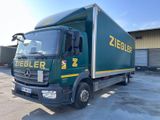 un camion vert garé sur un parking