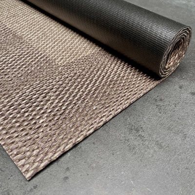 un gros plan sur un tapis sur lequel est posé un rouleau de tissu