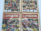 Quatre bandes dessinées sont exposées sur une étagère dans un magasin.