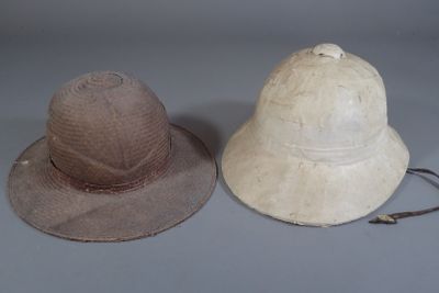 Deux casques coloniaux. Un en liège recouvert de toile plast…
