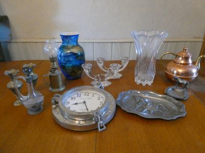 une table en bois sur laquelle se trouvent une horloge et divers objets en verre