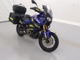une moto bleue et jaune garée dans une pièce