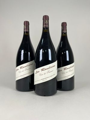 three bottles of red wine are lined up on a white surface