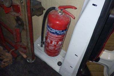 un extincteur rouge à côté de la portière d'une voiture