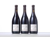 three bottles of wine are lined up on a table