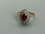a picture of a ring with a ruby and diamond center