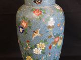 a blue vase with flowers and birds painted on it