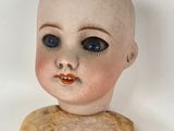 a small doll that is sitting on a white surface
