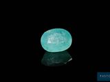 an oval aquamarinee stone on a black surface