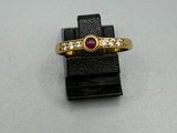 une image d'une bague en or avec une pierre en rubis