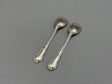 pair of silver spoons on a gray surface