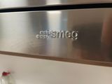 a close up of a stainless steel oven with a bottle of milk on the counter
