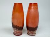 two vases sitting next to each other on a white surface