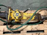 une machine jaune avec un tuyau vert posée sur une palette