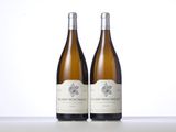 two bottles of wine sitting on top of a table next to each other