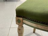 un fauteuil rembourré vert posé sur un sol carrelé blanc