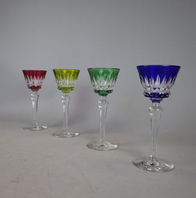 four wine glasses are lined up in a row on a table