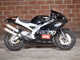 a black motorcycle parked in front of a brick wall