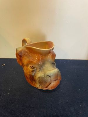 une petite tête d'animal en céramique posée sur une table bleue