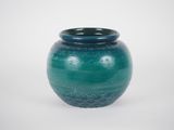 a blue vase that is sitting on a white surface