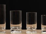 four tall glass vases sitting on a wooden table