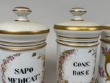 three white and gold canisters with floral designs on them