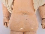 an old wooden doll with a white shirt on it