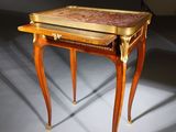 a small wooden table with a marble top on a grey floor
