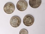 six different british coins are arranged in a row on a white surface