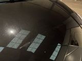 a reflection of a building on the windshield of a car
