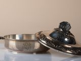 a silver bowl with a lid sitting on a table