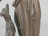 bronze statue of a woman with a dog on a marble base