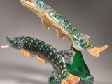 two figurines of two fish on top of a rock on a table