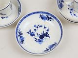 three blue and white plates and cups on a table