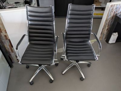 paire de fauteuils de bureau en cuir noir avec accoudoirs chromés et roulettes