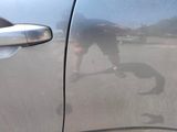 a reflection of a man on the side of a car