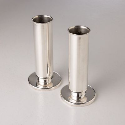 pair of silver plated candlesticks on a white surface