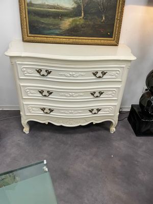 Une commode en bois laqué blanc ouvrant par 3 tiroirs style …