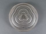 a silver plate with a design on it on a gray surface