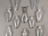 six clear glass bottles are arranged in a row on a gray surface