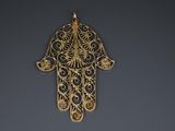 a close up of a gold hamsa hand hanging on a wall