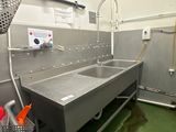 un lavabo au milieu d'une pièce au sol recouvert d'un revêtement vert