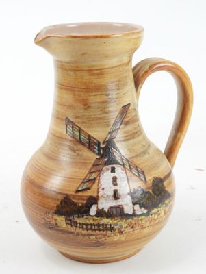 a brown pitcher with a windmill on it