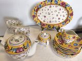 de nombreuses assiettes et tasses sur une table, avec une théière