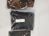 three bags of clothing are sitting on a white surface