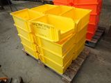 yellow and orange plastic containers stacked on a pallet in a warehouse