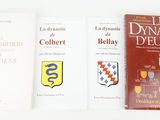 trois livres sont posés les uns à côté des autres sur une surface blanche