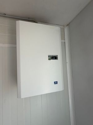une photo d'un tableau électrique blanc fixé au mur