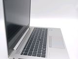 a silver laptop with a black keyboard on a white surface