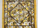 a yellow and black square scarf with cartoon characters on it